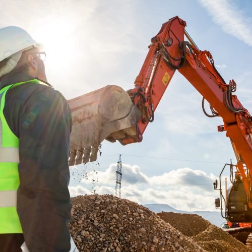 construction worker or engineer on construction site with excava